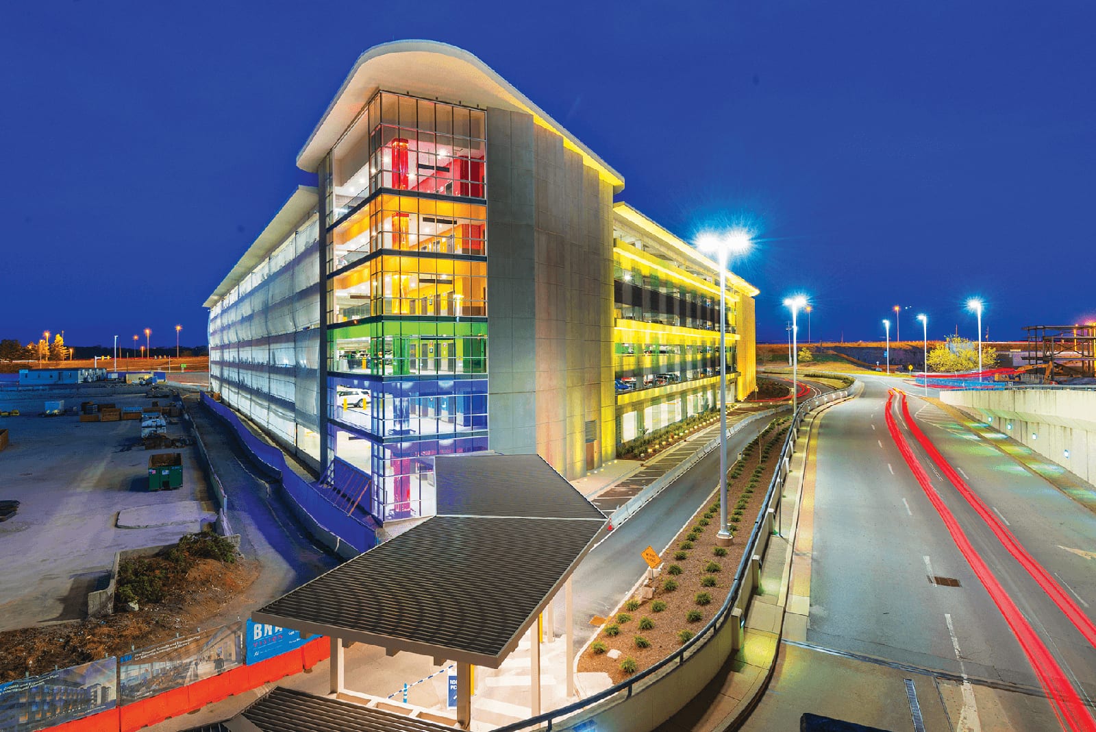 Photo of the corner of large airport building with rainbow colored window-panes lining each of the six floors.